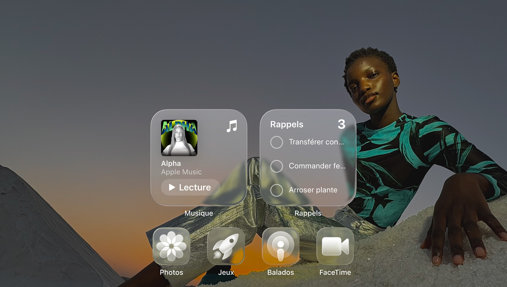 Affichage en Liquid Glass avec des icônes d’apps transparentes comme Musique, Rappels, Photos, Jeux, Balados et FaceTime avec un effet de réfraction sur le fond d’écran