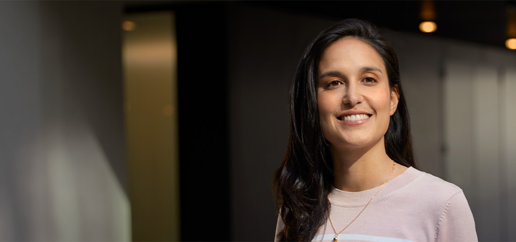 Camila a sorrir no interior de um escritório.