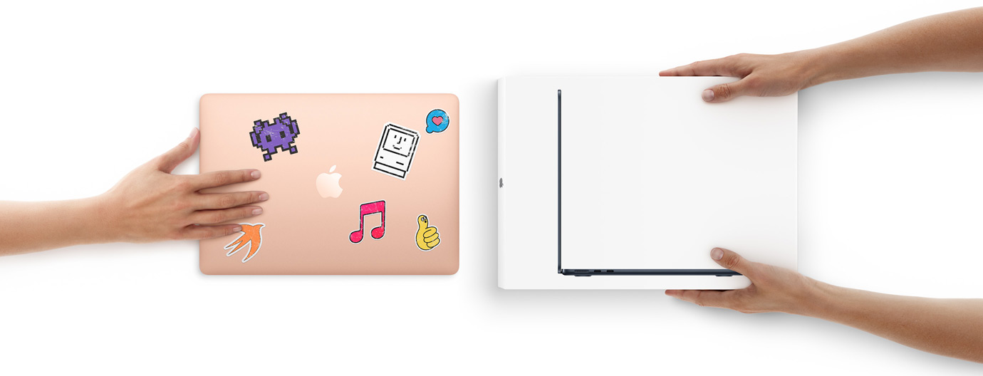 En hånd skyver en MacBook med klistremerker på dekselet mot to hender som holder en ny MacBook i esken.
