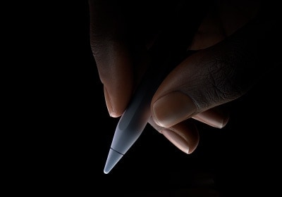 Uživatel drží Apple Pencil Pro v dolní třetině úchopem pro psaní.