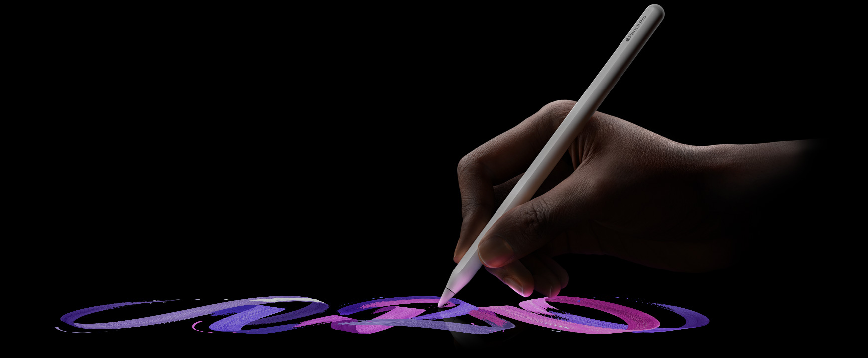Uživatel drží Apple Pencil Pro, následuje výrazně barevný tah štětcem
