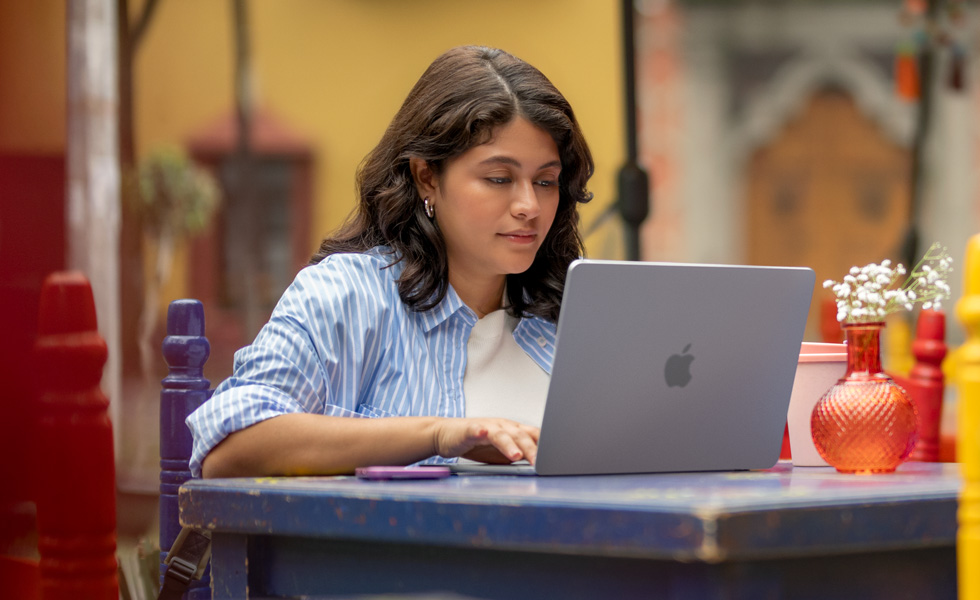 นักศึกษากำลังพิมพ์งานบน MacBook ของตัวเอง