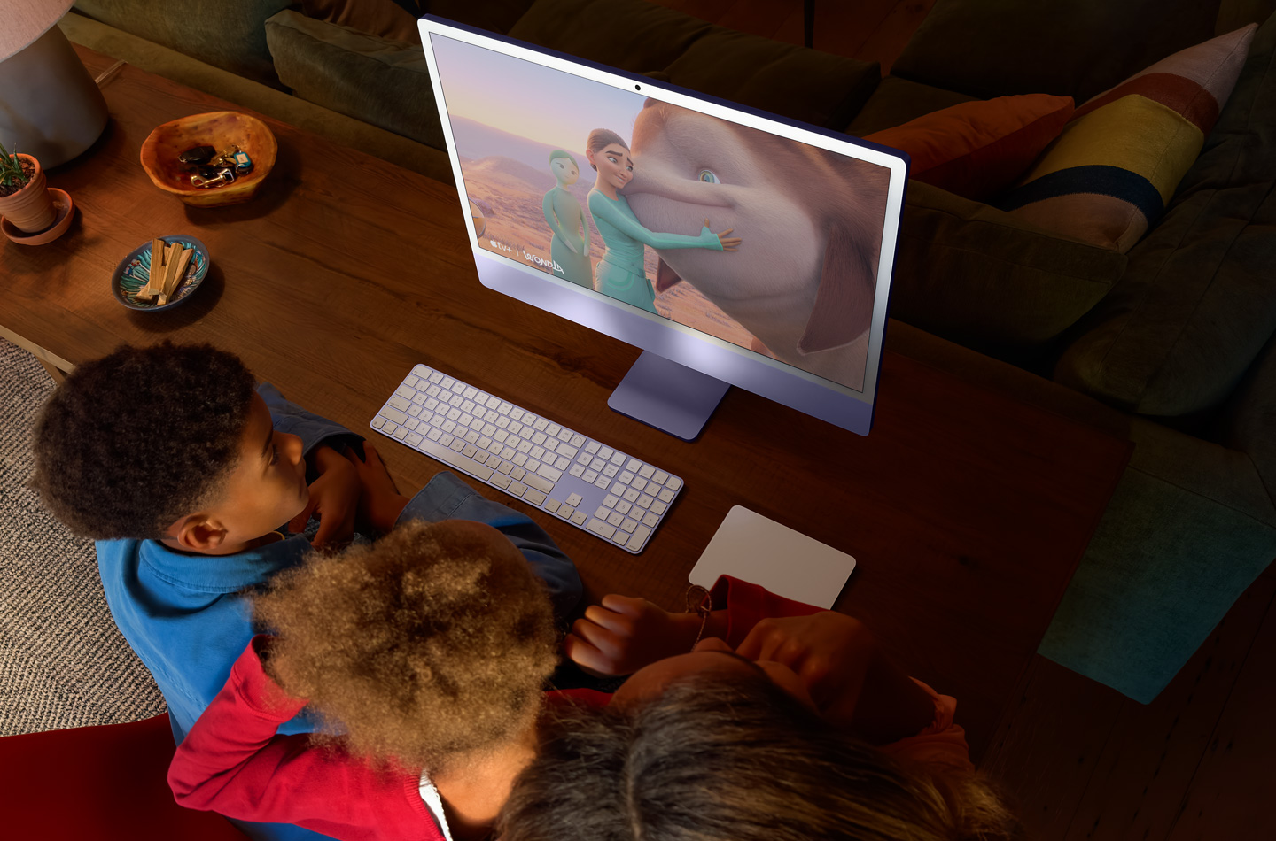 Tres niños viendo WondLa en una iMac