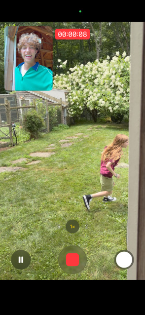iPhone 17 a usar a câmara frontal e traseira para gravar um vídeo em captura dupla de uma menina a correr e do pai a observar