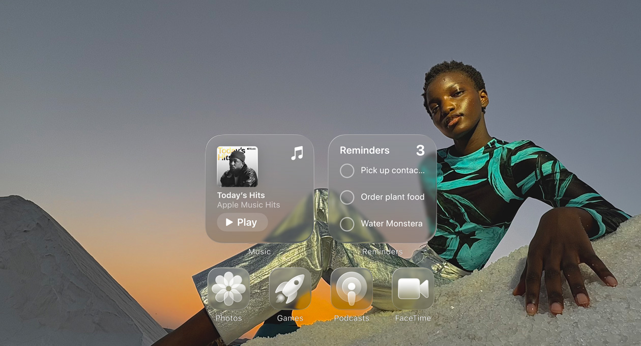 Liquid Glass display with clear app icons, like Apple Music, Reminders, Photos, Games, Podcasts and FaceTime refracting against the wallpaper