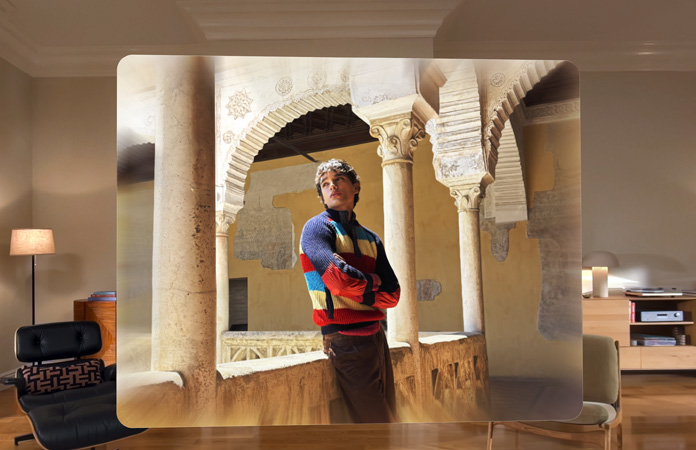 Scène spatiale montrant la photo d’un homme appuyé contre le balcon d’une cour sinueuse, de la profondeur et du relief dans le cadre